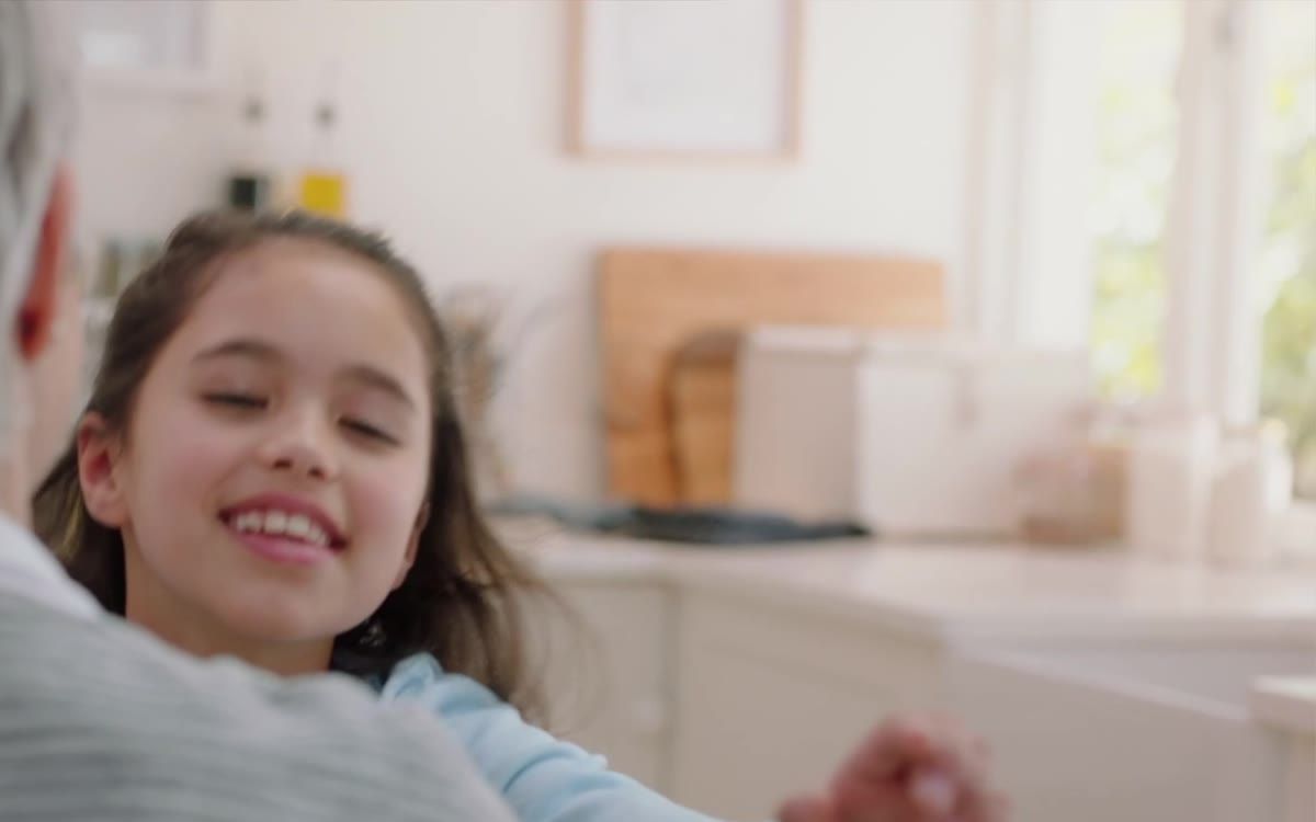 Una niña sonríe en una cocina